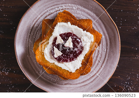 Close up of sweet toasts with ricotta, berry jam and pastila on a plate on the table top view Close up of sweet toasts with ricotta, berry jam and pastila on a plate on the table top view 136090523