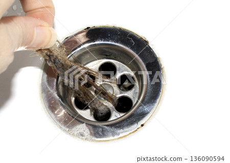 Unblocking brown hair from sink hole drain close up unhygenic gross job 136090594