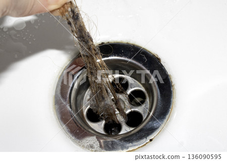 Unblocking brown hair from sink hole drain close up unhygenic gross job Unblocking brown hair from sink hole drain close up unhygenic gross job 136090595