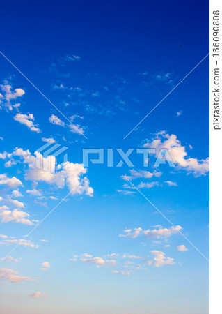 vertical blue sky with white soft clouds. clear atmosphere for summer weather background. peaceful nature on a sunny morning. scenic outdoor pattern for meteorology or idyllic holiday aesthetic 136090808
