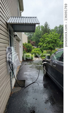Home electric vehicle charging station protection in rain Home electric vehicle charging station protection in rain 136091769