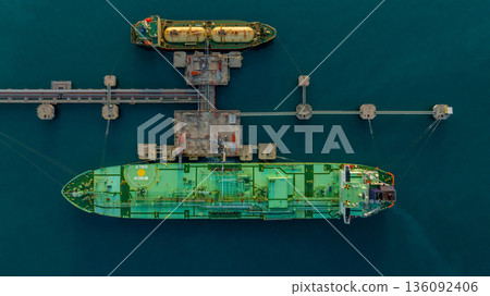 Aerial view LPG tanker ship at oil and gas terminal platform, Liquefied Petroleum Gas tanker ship industrial oil gas terminal tanker ship, LPG tanker ship loading and unloading petrochemical industry. Aerial view LPG tanker ship at oil and gas terminal platform, Liquefied Petroleum Gas tanker ship industrial oil gas terminal tanker ship, LPG tanker ship loading and unloading petrochemical industry. 136092406