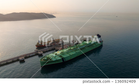 Aerial view LPG tanker ship at oil and gas terminal platform, Liquefied Petroleum Gas tanker ship industrial oil gas terminal tanker ship, LPG tanker ship loading and unloading petrochemical industry. Aerial view LPG tanker ship at oil and gas terminal platform, Liquefied Petroleum Gas tanker ship industrial oil gas terminal tanker ship, LPG tanker ship loading and unloading petrochemical industry. 136092409