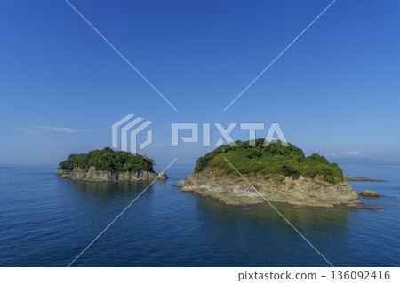 兩座小島漂浮在蔚藍的大海上,構成了一幅寧靜的夏日海景。 兩座小島漂浮在蔚藍的大海上,構成了一幅寧靜的夏日海景。 136092416