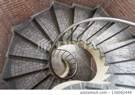 Architectural structure of a spiral staircase surrounded by brick walls Architectural structure of a spiral staircase surrounded by brick walls 136092448