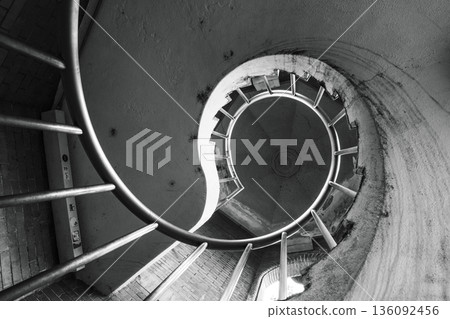 Monochrome space of a spiral staircase captured with an upward-looking composition Monochrome space of a spiral staircase captured with an upward-looking composition 136092456