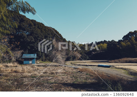 A blue tin hut at the foot of a rural mountain and fallow fields in winter A blue tin hut at the foot of a rural mountain and fallow fields in winter 136092648