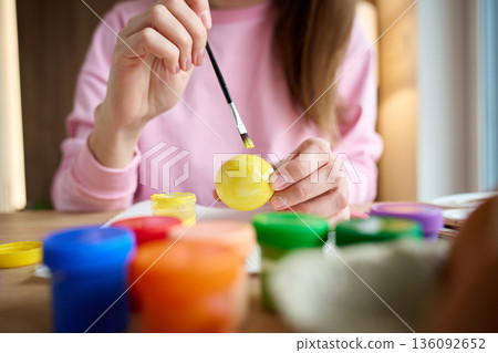 Woman painting Easter egg with colorful paints Woman painting Easter egg with colorful paints 136092652