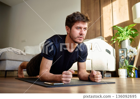 Man doing plank exercise on fitness mat at home Man doing plank exercise on fitness mat at home 136092695
