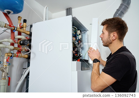 Technician open control unit to inspecting heat pump system in house 136092743
