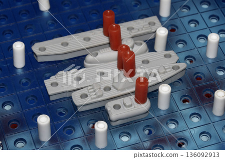 Close up of strategic battleships board game with ships and pegs Close up of strategic battleships board game with ships and pegs 136092913
