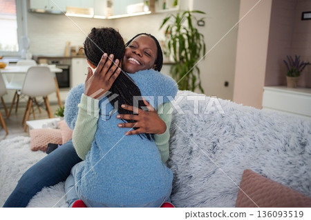 Mother and daughter embracing with love and affection at home 136093519
