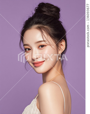 Smiling Asian woman against a purple background, beauty image with bun hair and summer clothes 136093677