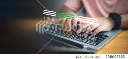 Close up hand typing on laptop with virtual digital checklist icons. Concept of online survey, business data management, and quality control technology. 136093863