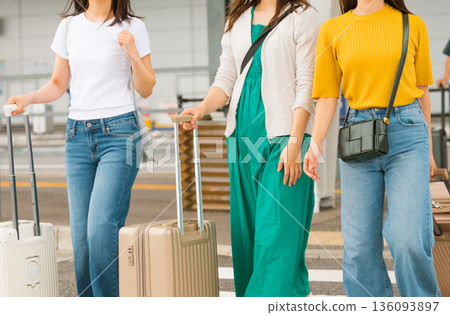 Three women pulling suitcases at the airport. Photo courtesy of Kansai International Airport (KIX). Three women pulling suitcases at the airport. Photo courtesy of Kansai International Airport (KIX). 136093897