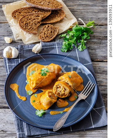 Stuffed cabbage rolls with quinoa and tomato sauce 136093911