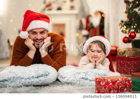 Father and daughter wearing santa hats enjoying Christmas holiday 136094015