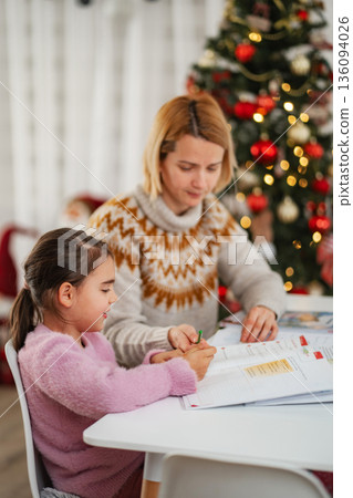Mother and daughter studying homework during Christmas holidays 136094026