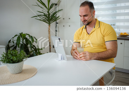 Man teleconferencing from home using digital tablet technology Man teleconferencing from home using digital tablet technology 136094136