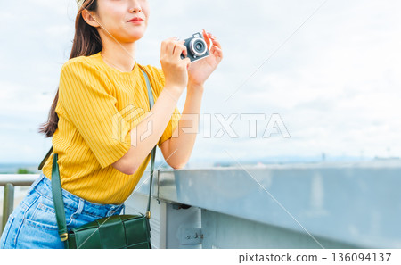 一位女士正在用相機拍攝風景。照片由關西國際機場（KIX）提供。 136094137