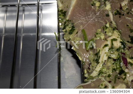 Raw seasoned lamb meat steak on a grill smoker waiting to be cooked 136094304
