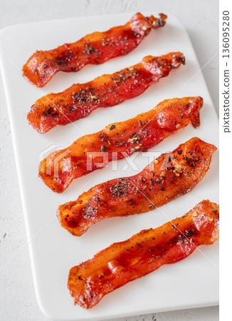 Billionaire bacon strips glazed with pepper and chili flakes on minimalist plate Billionaire bacon strips glazed with pepper and chili flakes on minimalist plate 136095280