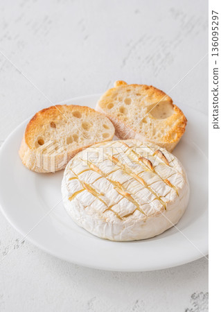 Baked camembert with toasted ciabatta garlic and rosemary garnish Baked camembert with toasted ciabatta garlic and rosemary garnish 136095297