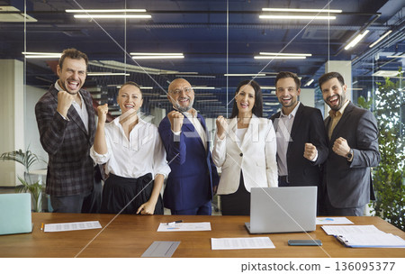 Celebrating corporate success: happy business team cheering in office together Celebrating corporate success: happy business team cheering in office together 136095377