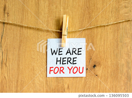 Support, help and we are here for you symbol. Concept words We are here for you on beautiful white paper on clothespins. Beautiful wooden background. Business we are here for you concept. Copy space. 136095503