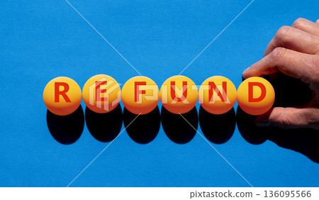 Refund word symbol. Concept word Refund on beautiful orange table tennis ping pong balls. Beautiful blue background. Businessman's hand. Business word refund concept. Copy space. Refund word symbol. Concept word Refund on beautiful orange table tennis ping pong balls. Beautiful blue background. Businessman's hand. Business word refund concept. Copy space. 136095566