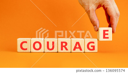 Courage symbol. Concept word Courage on beautiful wooden blocks. Beautiful orange background. Businessman's hand. Business courage concept. Copy space. Courage symbol. Concept word Courage on beautiful wooden blocks. Beautiful orange background. Businessman's hand. Business courage concept. Copy space. 136095574