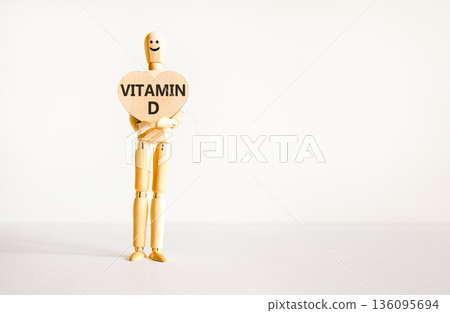 Vitamin D symbol. Concept words Vitamin D on beautiful wooden heart. Doctor's model. Beautiful white background. Copy space. Medical healthy lifestyle Vitamin D concept. 136095694