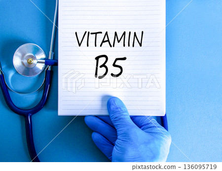 Vitamin B5 pantothenic acid symbol. Concept words Vitamin B5 on beautiful white note. Doctor's hand in blue medical glove. Beautiful blue background. Medical healthy lifestyle Vitamin B5 concept. Vitamin B5 pantothenic acid symbol. Concept words Vitamin B5 on beautiful white note. Doctor's hand in blue medical glove. Beautiful blue background. Medical healthy lifestyle Vitamin B5 concept. 136095719