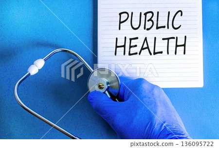 Public health symbol. Concept words Public health on beautiful white note. Doctor's hand in blue medical glove. Stethoscope. Beautiful blue background. Medical healthy lifestyle public health concept 136095722