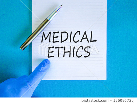 Medical ethics symbol. Concept words Medical ethics on beautiful white note. Doctor's hand in blue glove. Pen. Beautiful blue background. Medical healthy lifestyle medical ethics concept. 136095723