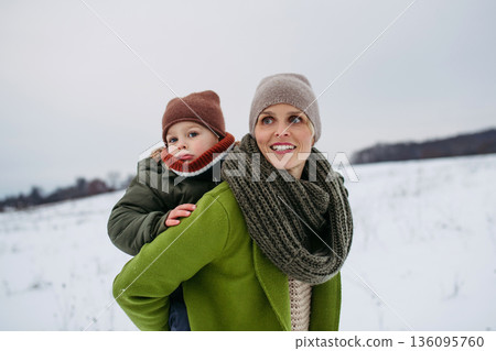 Mother on walk in winter nature with little son. 136095760