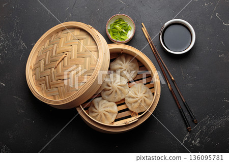 Chinese food dim sum bao dumplings bamboo steamer chopsticks black background Chinese food dim sum bao dumplings bamboo steamer chopsticks black background 136095781