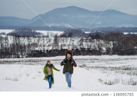 Father, mother and young son on walk in winter nature. Father, mother and young son on walk in winter nature. 136095785