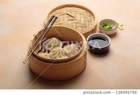 Steaming chinese dim sum bao dumplings chopsticks soy sauce asian bamboo steamer 136095798