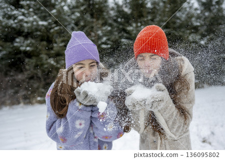 Sisters playing in snow. Winter excitement. Sisters playing in snow. Winter excitement. 136095802