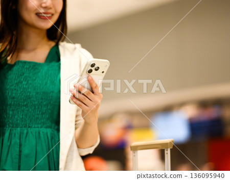A woman using a smartphone. Photo courtesy of Kansai International Airport (KIX). A woman using a smartphone. Photo courtesy of Kansai International Airport (KIX). 136095940