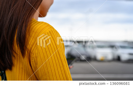 一位穿著黃色毛衣的女子和停車場 ■攝影合作：關西國際機場（KIX） 136096081