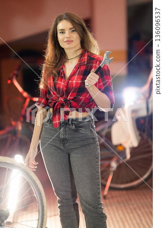 Young woman holding wrench ready for repair work Young woman holding wrench ready for repair work 136096537