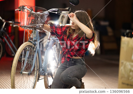 Young woman repairing bicycle feeling tired or frustrated Young woman repairing bicycle feeling tired or frustrated 136096566
