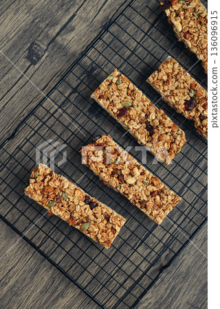 Gluten-free oat granola bars with nuts and berries on a black cooling rack Gluten-free oat granola bars with nuts and berries on a black cooling rack 136096915
