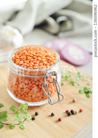 Raw dry red lentils with spices and herbs in a glass jar 136096962