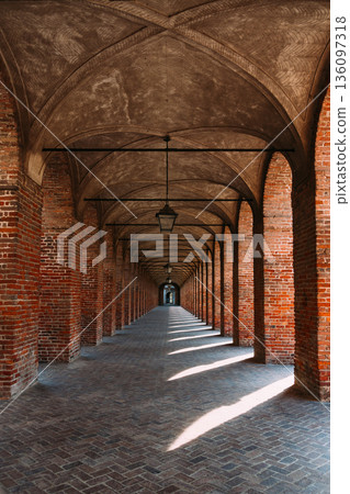 Symmetrical brick arcade in Sabbioneta, Italy, with long perspective 136097318
