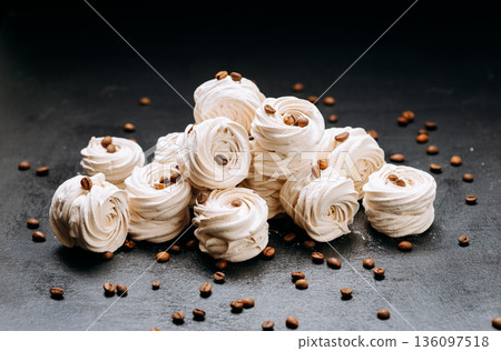Vanilla zephyr meringue cookies with coffee beans on dark slate background Vanilla zephyr meringue cookies with coffee beans on dark slate background 136097518
