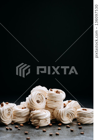 Coffee zephyr swirls with roasted beans on dark background, copy space Coffee zephyr swirls with roasted beans on dark background, copy space 136097530