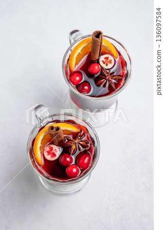 Two glasses of mulled wine, orange, cranberry, cinnamon, and star anise on a light background Two glasses of mulled wine, orange, cranberry, cinnamon, and star anise on a light background 136097584